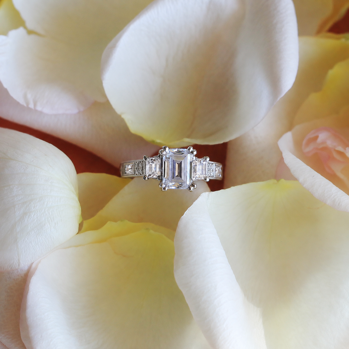 View of deco three-stone engraved baguette diamond engagement ring.