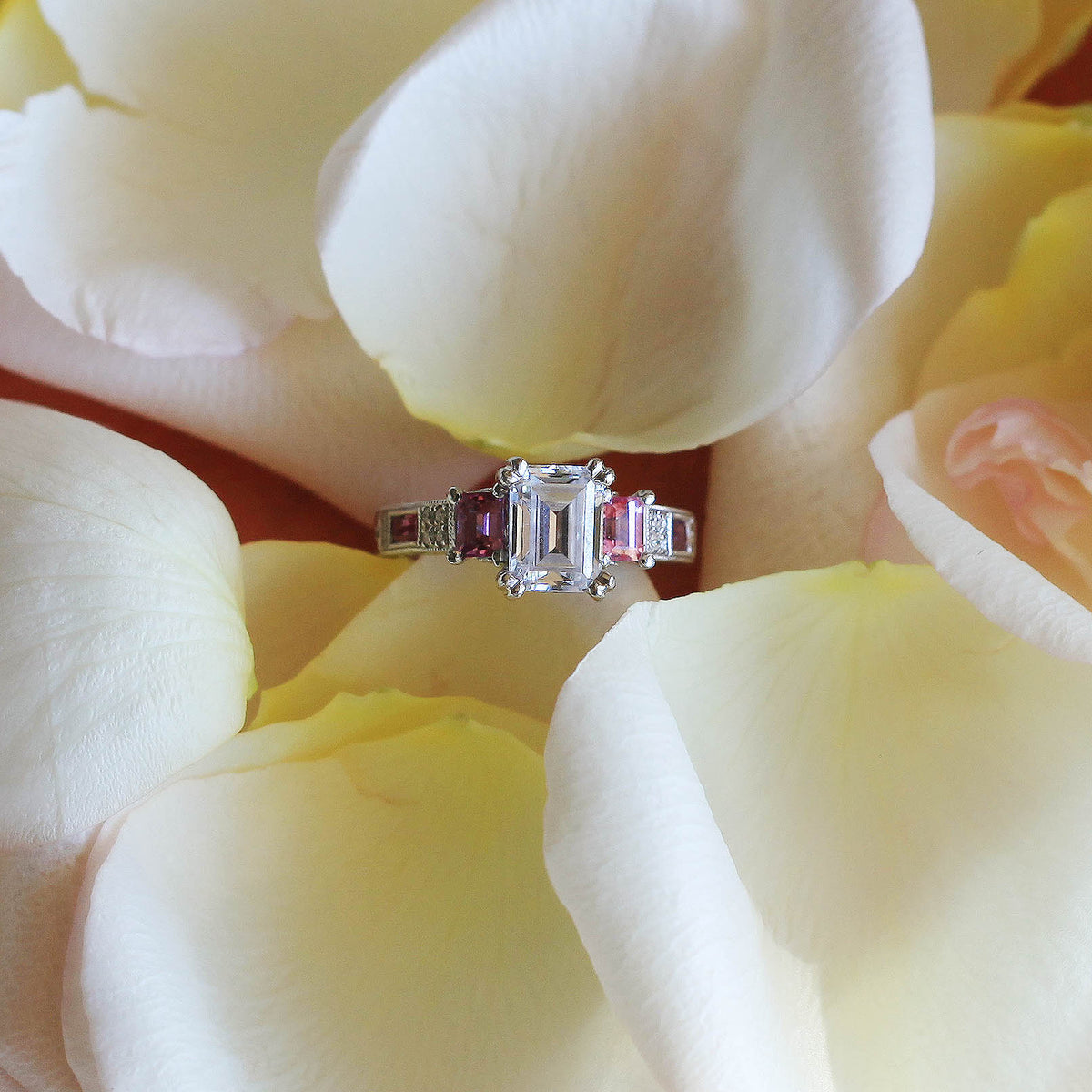 View of deco three-stone engraved sapphire baguette diamond engagement ring.