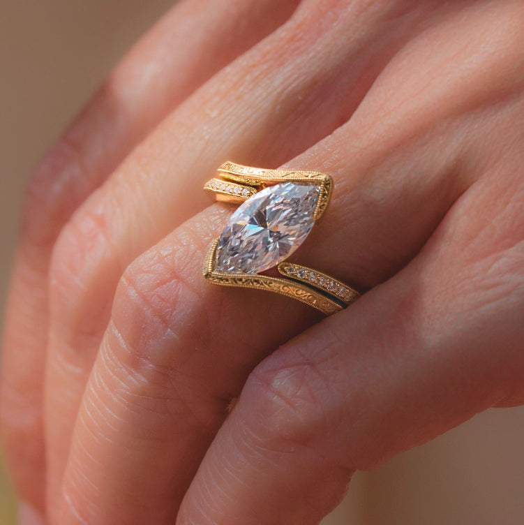 Worn on hand, showing hand-engraved wave bypass half bezel engagement ring.